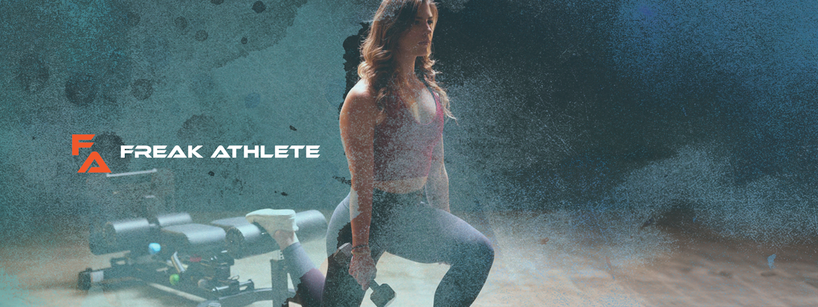A motivated female athlete in activewear performing a walking lunge in a gritty, industrial-style gym. The atmosphere conveys determination and strength, emphasized by the 'FREAK ATHLETE' logo overlay in bold orange, suggesting a brand that champions intense workouts and formidable athletic performance.